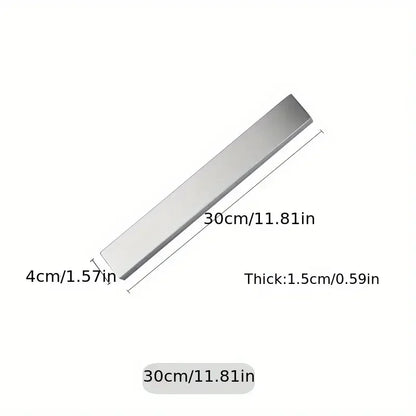 Stainless steel magnetic knife holder from Maison Verdane mounted on kitchen wall, holding knives securely.