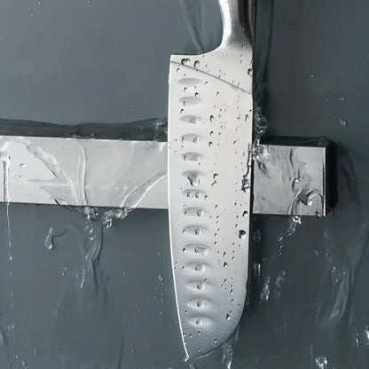 Stainless steel wall-mounted magnetic knife holder by Maison Verdane holding kitchen knives in a modern kitchen setting.