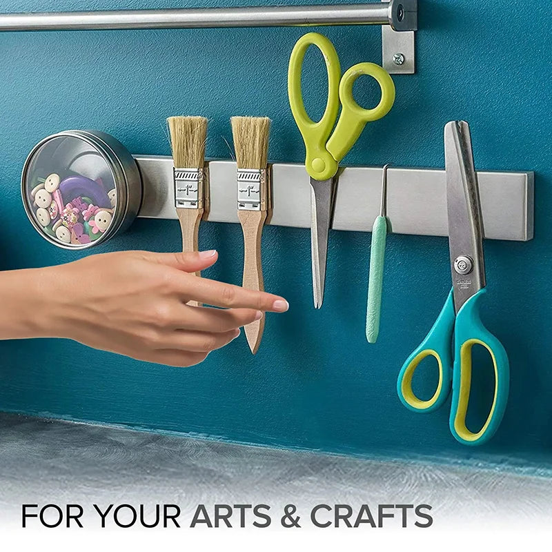 Stainless steel wall-mounted magnetic knife holder by Maison Verdane with multiple knives attached for organized kitchen storage